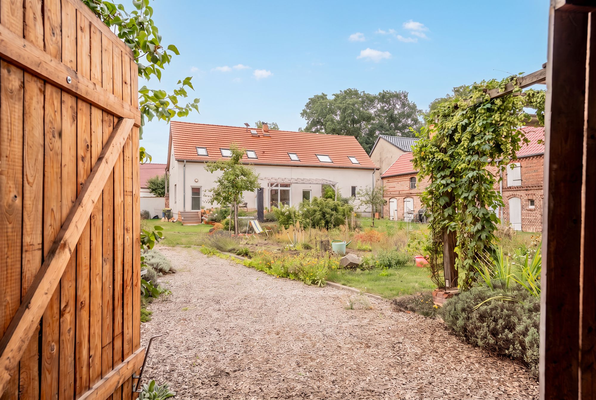 Vierseitenhof bei Brandenburg – Blick durch das Scheunentor auf Hof und Wohnhaus